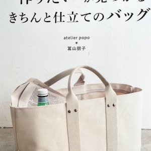 May include: A beige canvas tote bag with sturdy handles and reinforced straps. The bag has a front pocket containing a newspaper and a green bottle. The text on the bag reads "Pomadour's". The top of the image has Japanese text.