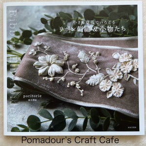 Puede incluir: Una portada de libro con un fondo marrón y bordado de cinta blanca. El título es "Bordado de cinta: Pequeñas flores y pequeñas criaturas" en japonés. El autor es "poritorie" y el libro es publicado por "Nihon Bungesha"