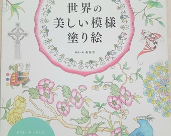 May include: A coloring book with the title "Beautiful Patterns of the World" in Japanese. The cover features floral and bird illustrations in pastel colors, with text in Japanese and English. The book is from "Pomadour's".
