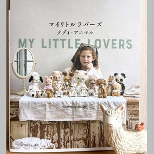 Könnte beinhalten: Ein Nähbuch mit dem Titel My Little Lovers, das eine Sammlung kleiner handgefertigter Plüschtiere auf einem Tisch zeigt. Das Cover enthält den Text applemints, My Little Lovers und Sewing Book sowie ein Kind hinter den Stofftieren.