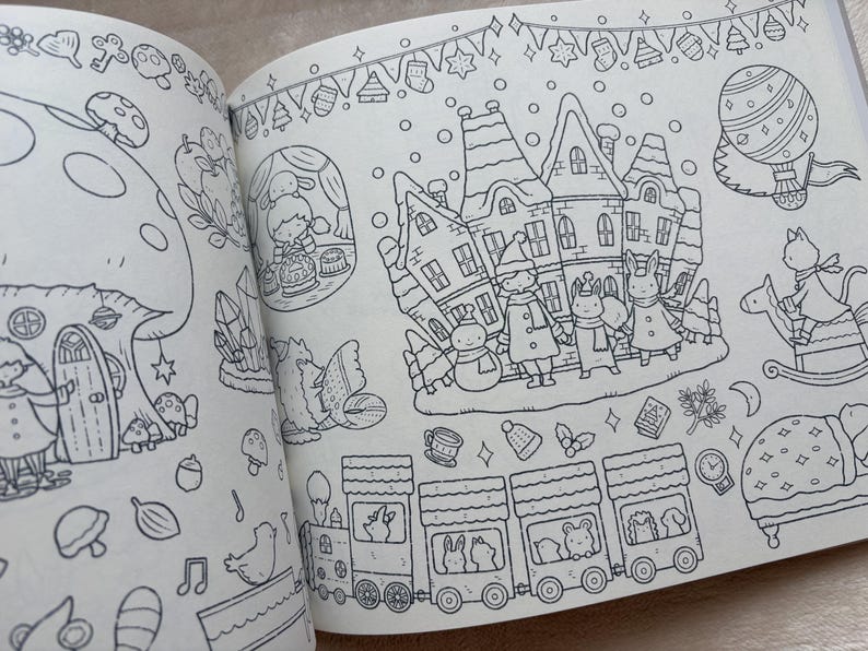 May include: Open coloring book pages with detailed black and white illustrations. One page depicts a fairy village with houses, characters, and a train. The other page shows a large mushroom house and other fantasy elements. The drawings are outlined in black.