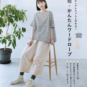 Puede incluir: Una portada de revista con una mujer que lleva una camisa a rayas blancas y negras, pantalones blancos y zapatillas blancas. La portada de la revista se titula "Guardarropa fácil y que ahorra tiempo" en japonés. El texto de la portada también dice "¡No se necesita patrón, puedes hacerlo!" y "¡Fácil de coser con líneas rectas!"