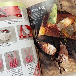 May include: A book with instructions on how to make a traditional Japanese doll and bamboo shoot ornaments. The book is open to a page showing a close-up of the doll and a page showing the bamboo shoot ornaments.