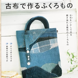 Può includere: Copertina di un libro con una borsa a tracolla in patchwork blu e bianco. Il titolo è "Vecchi tessuti per fare borse" in giapponese. Il libro è di Wakuko.