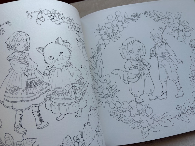 Pu&ograve; includere: Una doppia pagina di un libro da colorare con illustrazioni dettagliate a tratto. Una pagina mostra una ragazza e un gatto in abiti, che trasportano cesti. L'altra pagina raffigura un cane con un cappello e un ragazzo, circondati da motivi floreali e di bacche.