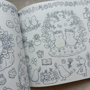 May include: A black and white illustration of a coloring book page with spring-themed drawings. The page features birds, bunnies, flowers, birdhouses, and other seasonal elements. The drawings are detailed and whimsical.