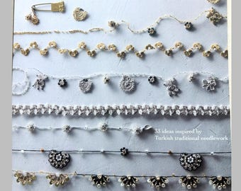 May include: A craft book cover titled "トルコの伝統手芸・オヤ ビーズの縁飾り&アクセサリー" by Midori Nishida, featuring various rows of delicate needlework lace and beaded edgings in gold, silver, black, and white, with the text "33 ideas inspired by Turkish traditional needlework" and "Edging & Accessories with Bead by Crochet".