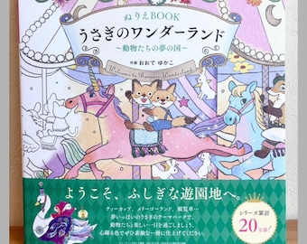 May include: A square coloring book titled "Usagi no Wonderland" featuring a colorful carousel illustration with a pink unicorn, a blue horse, and fox characters. The cover includes Japanese text, a green bottom border, and a circular badge stating 20万部.