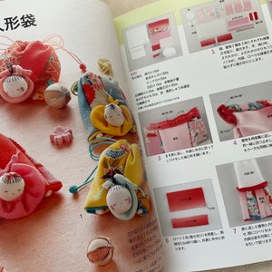 May include: A close-up of three handmade fabric dolls with colorful kimono-style outfits. The dolls are sitting on a pink surface with a white background. The dolls are about 3 inches tall and have black eyes and red lips. The dolls are wearing traditional Japanese clothing.