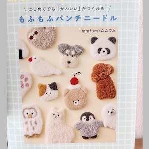 May include: A book cover featuring various fluffy animal punch needle designs, including a sloth, panda, dog, bird, cat, bear, owl, penguin, and seal. The title reads "OFUMOFU PUNCH NEEDLE" in large, colorful letters, with Japanese text below.