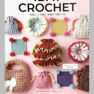 May include: A book cover featuring the title "1DAY CROCHET" in bold black letters. The cover showcases various crochet items in different colours, such as bags, squares, and a ruffled design. The text "Heart Warming Life Series" is also visible.