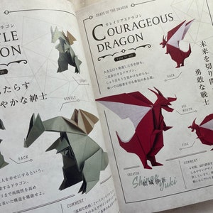 May include: Two origami dragons, one red and one green, are shown folded in different poses. The red dragon is labeled "Courageous Dragon" and the green dragon is labeled "Gentle Dragon". The book page features Japanese text and illustrations.