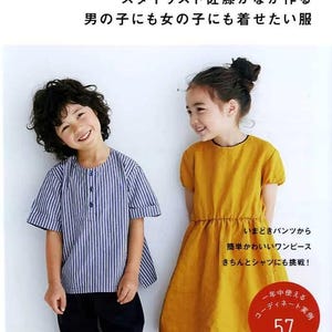 May include: A book cover featuring two children, a boy in a blue and white striped shirt and black pants, and a girl in a yellow dress. The book title is "KANA'S STANDARD for kids II" with Japanese text.