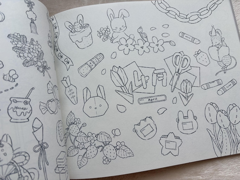 May include: A detailed black and white illustration featuring various spring-themed doodles. The drawings include bunnies, flowers, strawberries, carrots, scissors, and the word "April". The overall theme is a whimsical, hand-drawn style.