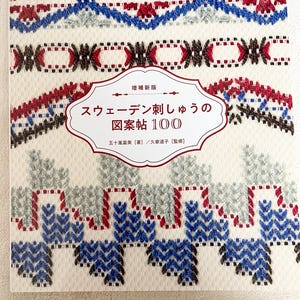 Puede incluir: Un libro titulado "Diseños de bordado sueco 100" con un fondo blanco y diseños de bordado coloridos en la portada. El libro es de Fumi Igarashi y presenta una etiqueta blanca con el título en negro.