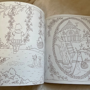 Puede incluir: Un libro para colorear abierto en dos p&aacute;ginas con dibujos lineales detallados. Una p&aacute;gina representa a una ni&ntilde;a en un columpio, la otra una casa en el &aacute;rbol caprichosa. Las ilustraciones est&aacute;n rodeadas de elementos florales y naturales.