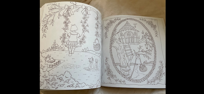 Puede incluir: Un libro para colorear abierto en dos p&aacute;ginas con dibujos lineales detallados. Una p&aacute;gina representa a una ni&ntilde;a en un columpio, la otra una casa en el &aacute;rbol caprichosa. Las ilustraciones est&aacute;n rodeadas de elementos florales y naturales.