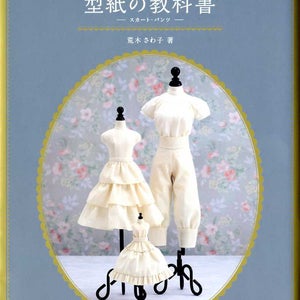 Könnte beinhalten: Ein Buch mit dem Titel "型紙の教科書 -スカート・パンツ-" von 瀧さゆり. Der Buchumschlag zeigt drei Schaufensterpuppen, die weiße Röcke und Hosen tragen. Der Hintergrund ist ein Blumenmuster.