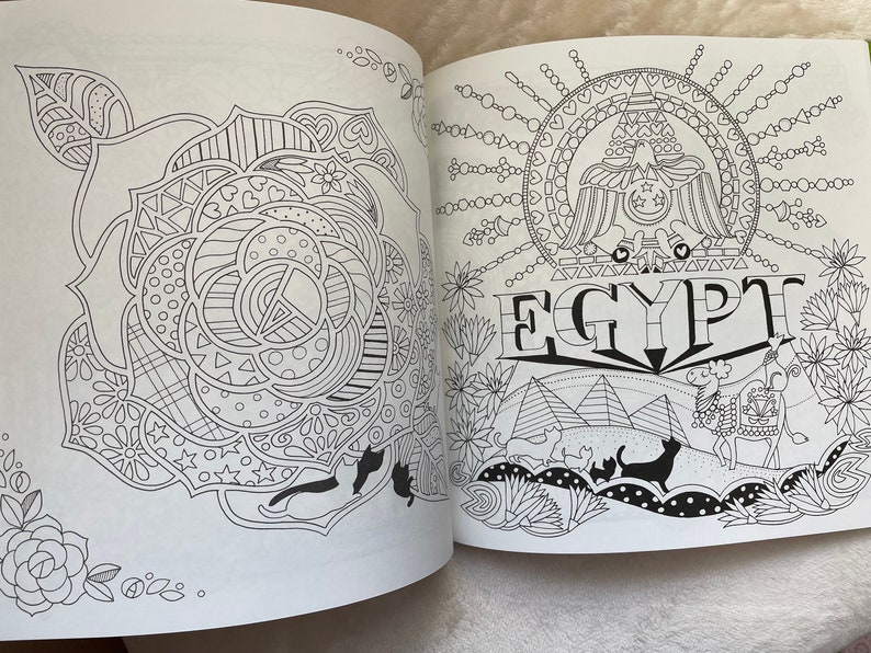 May include: A black and white coloring book page with a detailed illustration of a rose on the left side and an illustration of a stylized eagle with the word "EGYPT" below it on the right side.