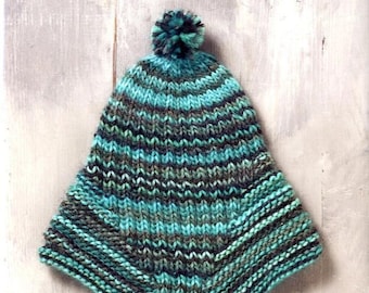 May include: A knitted hat in teal, grey, and black with a matching pom-pom. The hat is displayed on a light wooden surface. Text on the image reads "POMADOUR'S JAPANESE CRAFT" and Japanese text.