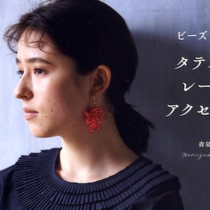 May include: A woman with dark hair wears a black shirt with a ruffled collar and red beaded earrings. The text "ビーズきらめく タティング レースの アクセサリー 森泉美苑 Maruzumi Nisane" is written in white on a grey background.