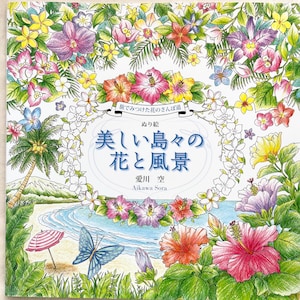 May include: A coloring book cover featuring a tropical beach scene with palm trees, flowers, and a butterfly. The title of the book is "Beautiful Islands Flowers and Scenery" in Japanese. The book is by Aikawa Sora.