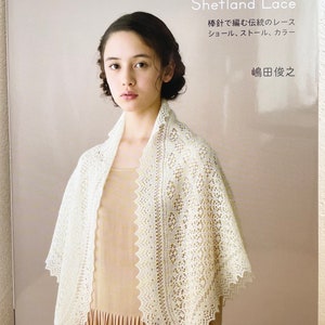 Op de afbeelding: Een boekomslag met een vrouw die een witte kant shawl draagt. De titel van het boek is "Shetland Lace" en de auteur is "Junji Shimada".