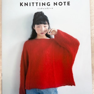 May include: A woman in a red knitted sweater and blue jeans is on the cover of a book. The book's title is "KNITTING NOTE" in large, bold letters, with Japanese text above. The word "Pomadour's" is at the bottom of the image.