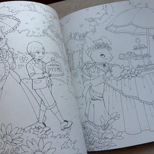 Pu&ograve; includere: Illustrazione dettagliata in bianco e nero da un libro da colorare. L'immagine raffigura animali antropomorfi in un ambiente di giardino. Un gatto con un ombrello e un giovane con una torta camminano in un giardino. Un coniglio &egrave; seduto a un tavolo con un vassoio per torte a pi&ugrave; livelli.