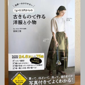 May include: A Japanese craft book cover featuring a person wearing a white short-sleeved top and a long olive green patterned skirt. The cover includes Japanese text, a YouTube subscriber count of 24.6 million, and a small drawstring pouch accessory.