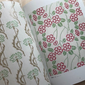 May include: Two pages from a book showing cross-stitch patterns. The left page shows a pattern of green and brown flowers with vines. The right page shows a pattern of red flowers with green leaves and vines. The page number is 66 and the text "花柄" is visible.