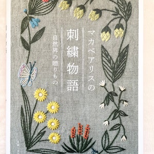 以下が含まれることがあります： 「刺繡物語」というタイトルの書籍の表紙。表紙には、蝶やテントウムシなどの昆虫が描かれた、花柄の刺繍デザインが施されています。