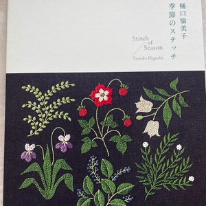 May include: A book titled "Stitch of Season" by Yumiko Higuchi. The cover features a black background with colorful embroidered flowers and leaves.