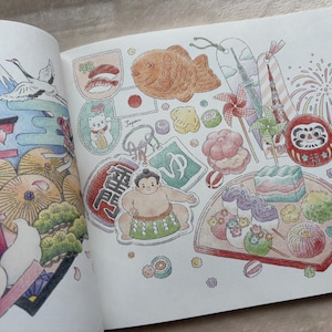 以下が含まれることがあります： 富士山、鳥居、食べ物など、日本の文化的なアイコンが描かれた詳細なイラスト。ダルマ人形、力士、招き猫が柔らかなパステルカラーで描かれています。塗り絵の本のページです。