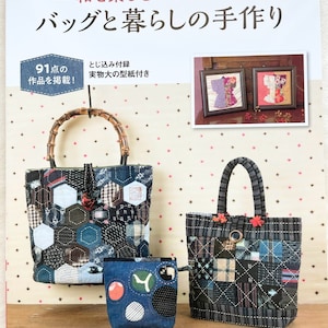 May include: A book cover with the title "和を楽しむパッチワーク バッグと暮らしの手作り" (Enjoying Patchwork Bags and Life) in Japanese. The cover features three patchwork bags in blue and black fabric with a variety of patterns. The book also includes a pattern for a small pouch.