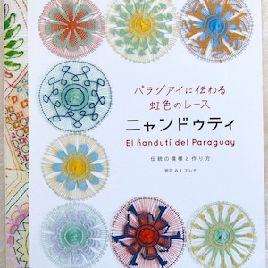 Peut inclure: Une couverture de livre avec le titre "Ñandutí del Paraguay" en espagnol et en japonais. La couverture présente des motifs de dentelle complexes et colorés dans une variété de couleurs, notamment le rouge, le bleu, le jaune et le vert. Le livre porte sur la technique traditionnelle de fabrication de dentelle paraguayenne.