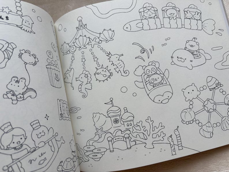 May include: A double-page spread from a colouring book, depicting various cartoon sea creatures and scenes. The illustrations include a carousel with seahorses and pufferfish, and characters in vehicles. All drawings are outlined in black.