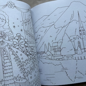 May include: A coloring book open to two pages. One page features a detailed illustration of a woman in a dress holding flowers. The other page shows a landscape with mountains, a church, and a lake, all in black and white line art.