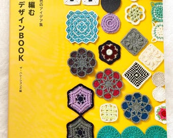 Puede incluir: Un libro amarillo titulado "Motif Design Book" en japonés, con varios motivos de ganchillo de diferentes colores y patrones. La portada muestra ejemplos de cuadrados, círculos y diseños florales de ganchillo.