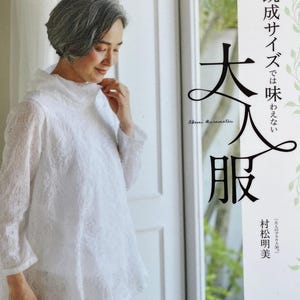 May include: A woman in a white, textured blouse with long sleeves and a high collar. The image also shows a book cover with Japanese text and the title "Adult Clothing". The blouse has an asymmetrical hem. The book cover also has the text "Akemi Muramatsu".