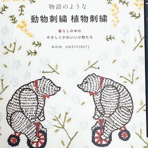 Puede incluir: Una portada de libro con fondo blanco y un patrón floral. El título es "Bordado de animales Bordado de plantas" en japonés. Dos osos bordados en triciclos aparecen en la portada. El texto "mmm bordado" también está en la portada.