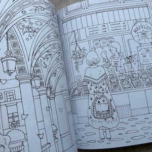 May include: A detailed black and white illustration from a coloring book. The image depicts a European street scene with a waffle shop and a woman in a patterned dress. The shop has a sign that says "Waffles!" and a menu board.