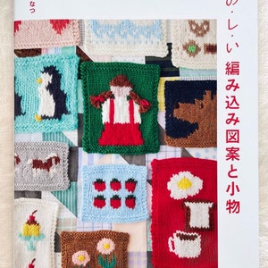 May include: A book cover featuring various knitted square designs with images of a penguin, strawberries, and other motifs. The title is in Japanese. The book is from Pomadour's Craft Cafe.