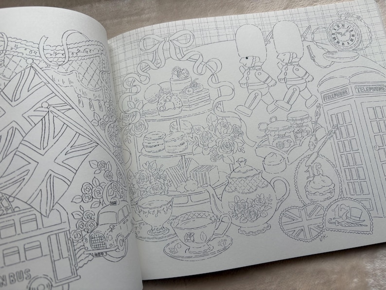 以下が含まれることがあります： イギリスのアイコンが描かれた、詳細な塗り絵ページ。2階建てバス、ユニオンジャックの旗、電話ボックス、行進する衛兵、ティーカップ、ケーキ、ティーポットが含まれています。イラストは白黒です。