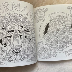 May include: A black and white coloring book page with a detailed illustration of a gingerbread house and a girl in a hooded cloak. The page is titled "GERMAN".