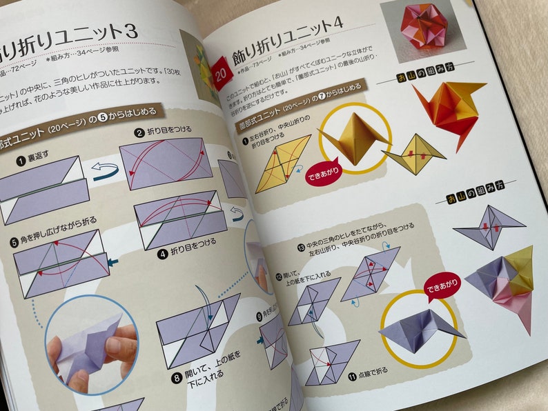 May include: A book with instructions on how to fold origami units. The book is open to a page showing the steps for folding a unit called "Folding Unit 3". The steps are illustrated with diagrams and arrows. The book also shows the finished origami unit.