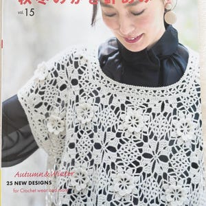 Könnte beinhalten: Ein Buch mit dem Titel "Herbst & Winter" mit dem Text "Let's knit series 秋冬のかぎ針あみ vol. 15" und "25 NEUE DESIGNS für Häkelkleidung und mehr". Das Cover zeigt eine Frau, die ein weißes Häkeltop mit einem schwarzen Shirt darunter trägt.