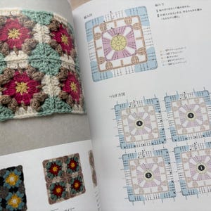 Puede incluir: Primer plano de un cuadrado tejido a ganchillo con cuatro dise&ntilde;os florales. Cada flor tiene un centro rosa, rodeado de p&eacute;talos marrones y crema. El fondo es de color verde claro. La imagen es de un libro de manualidades.