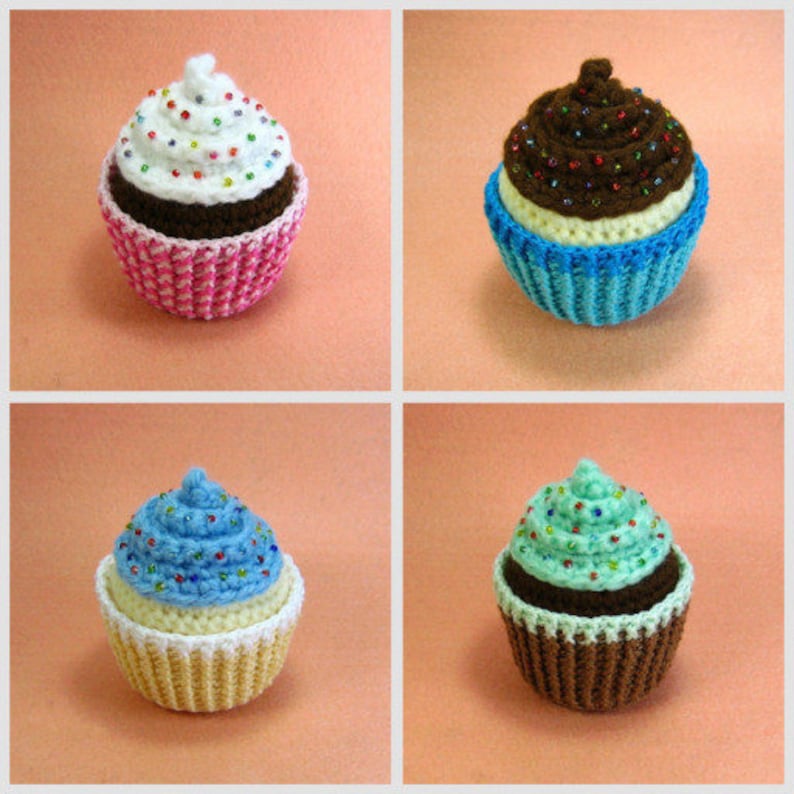 May include: Four crocheted cupcakes, each with a different colored frosting and sprinkles. The cupcakes are pink, blue, brown, and green.