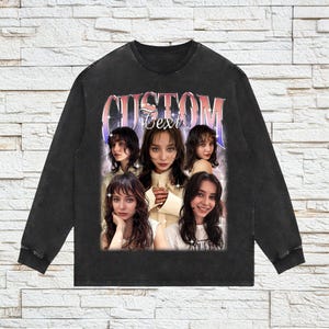 Pu&ograve; includere: Felpa nera a maniche lunghe con un aspetto vintage sbiadito. La parte anteriore presenta una grafica di una donna con il testo "CUSTOM Text" in un font retr&ograve;. La grafica include pi&ugrave; immagini della stessa donna.